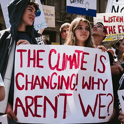 Protesters holding a sign reading ‘The climate is changing, why aren’t we?’